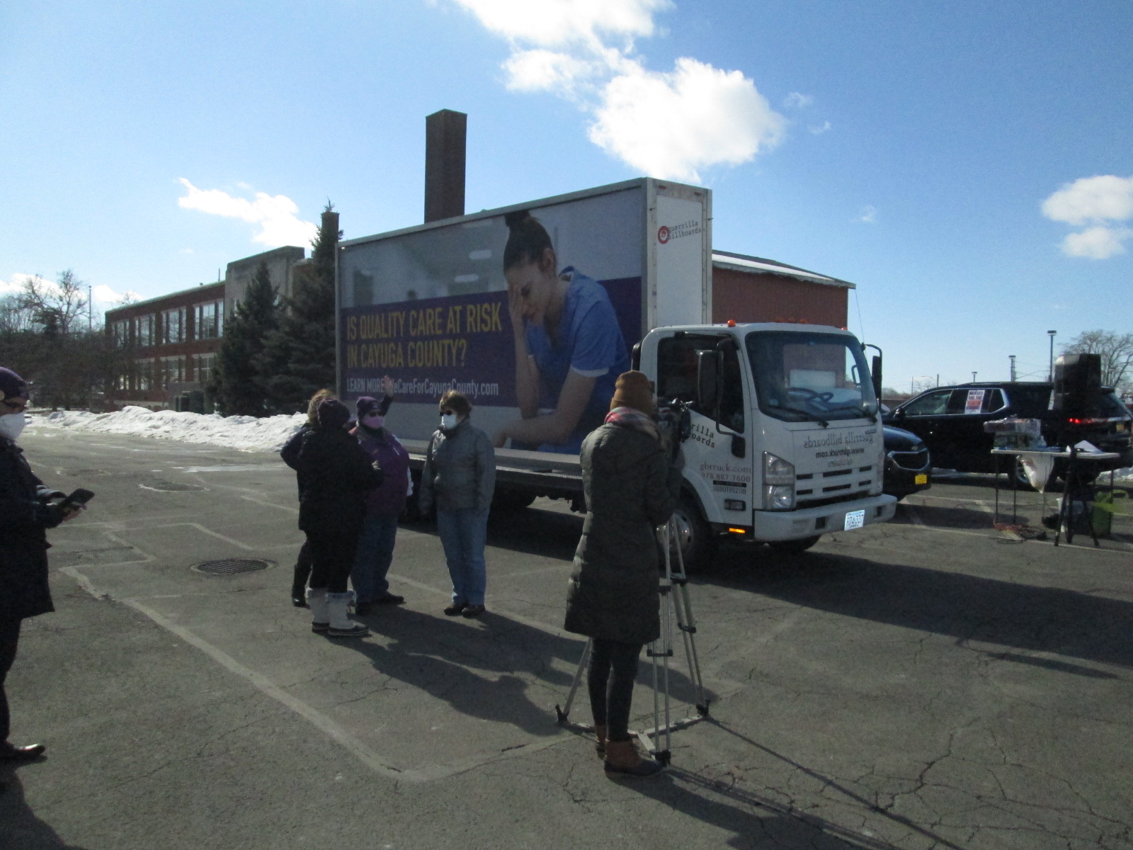 Billboard truck serving as a backdrop for TV reporter interviews.