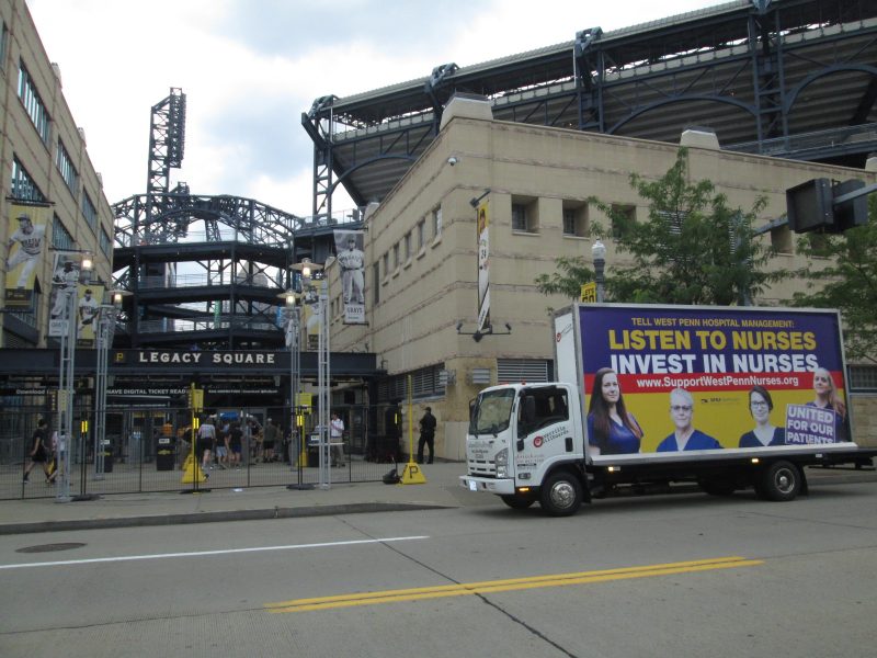Mobile billboard truck passing PNC Park in Pittsburgh