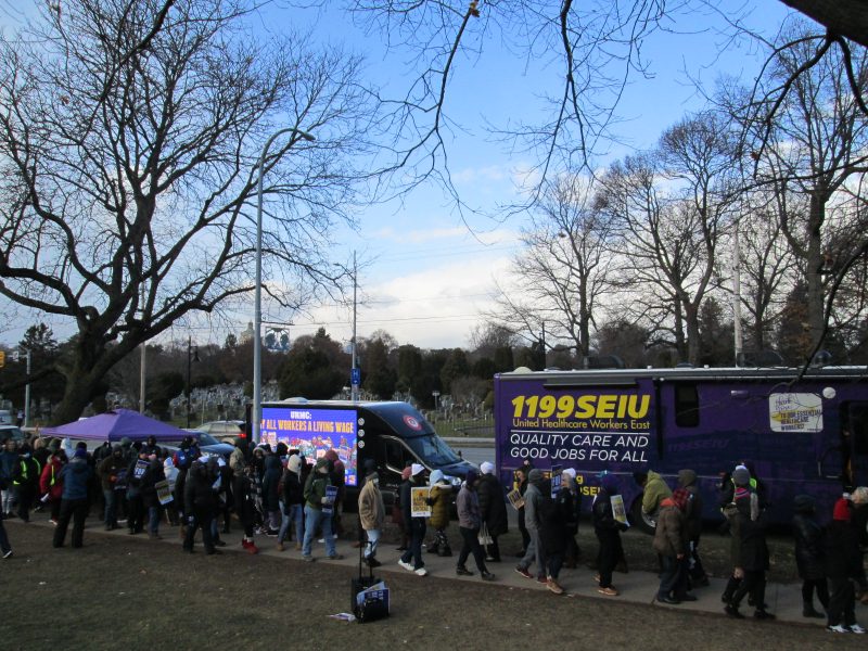 Union members on strike at URMC in Rochester NY, walking past an LED mobile billboard truck