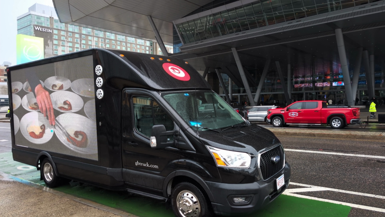 Digital LED mobile billboard ad truck stopped across from the Boston Convention and Exhibition Center, displaying prepared servings of plated Octopus.