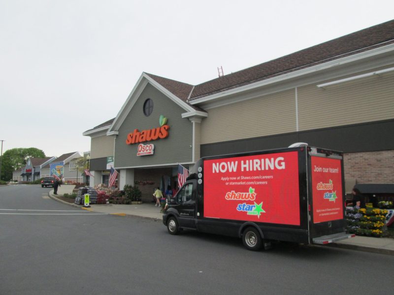 Mobile digital billboard truck with a NOW HIRING ad, stopped at a client location, during an employee recruiting campaign on Cape Cod.