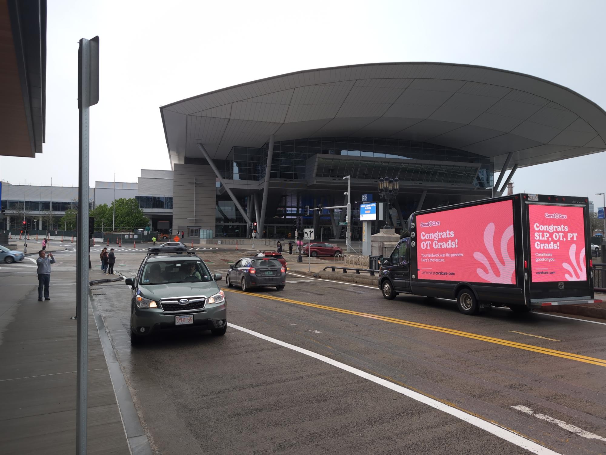 Mobile digital billboard truck passing the Boston Convention & Exhibition Center with an employee recruiting ad.