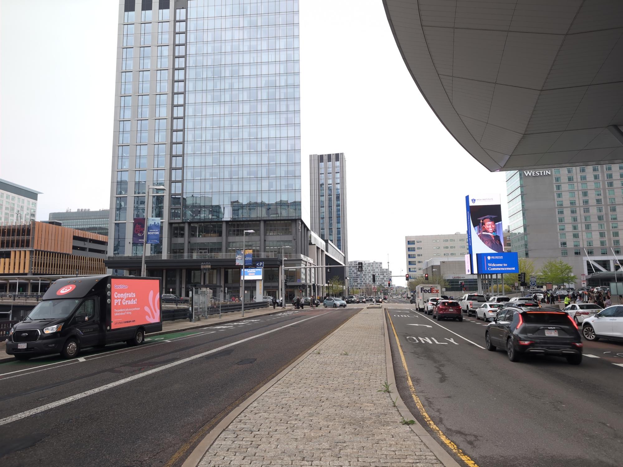 Mobile digital billboard truck displaying employee recruiting ads during a university graduation in Boston.