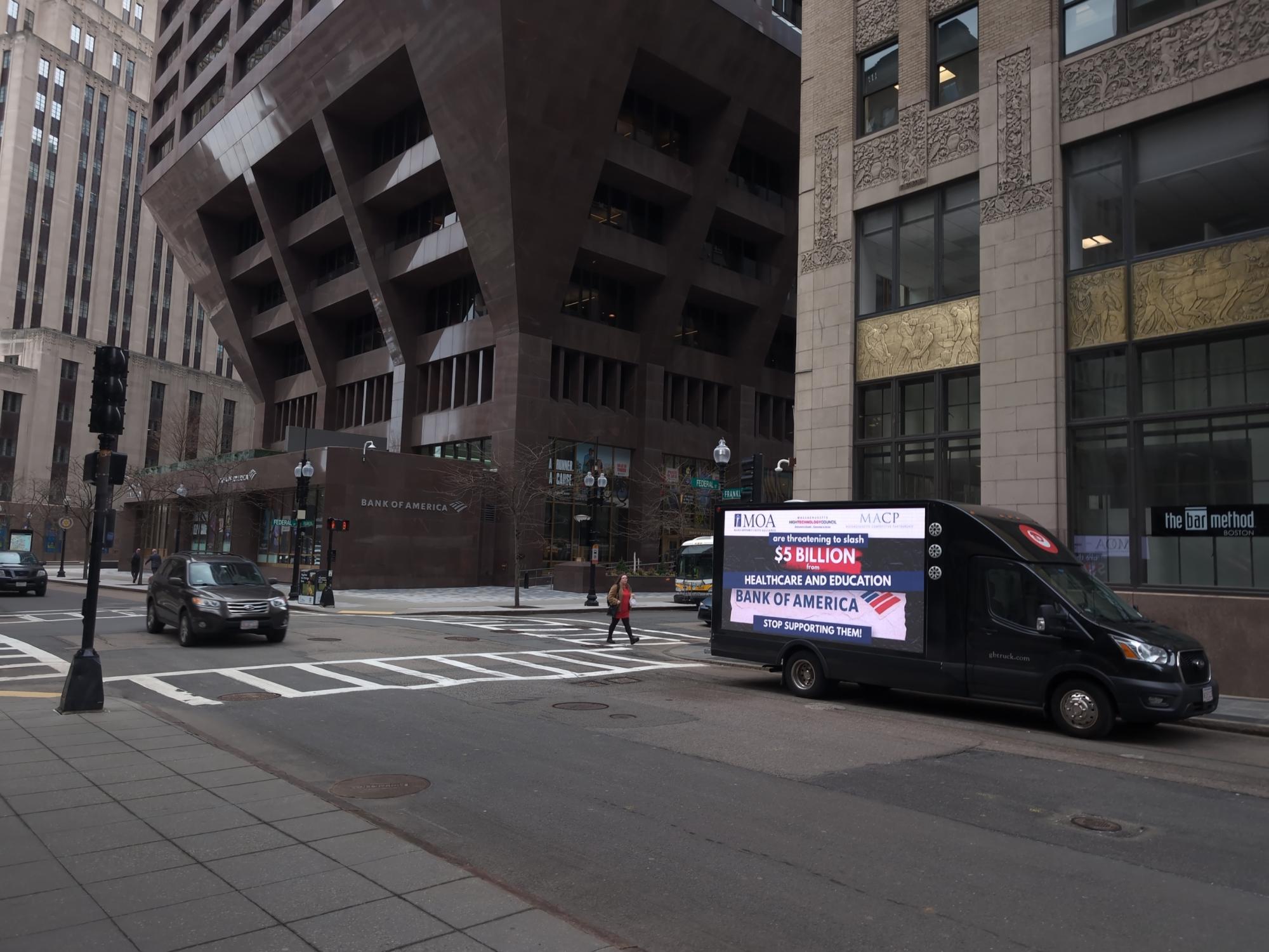 Digital mobile billboard truck stopped at the corner of Federal Street and Franklin Street in Boston MA.