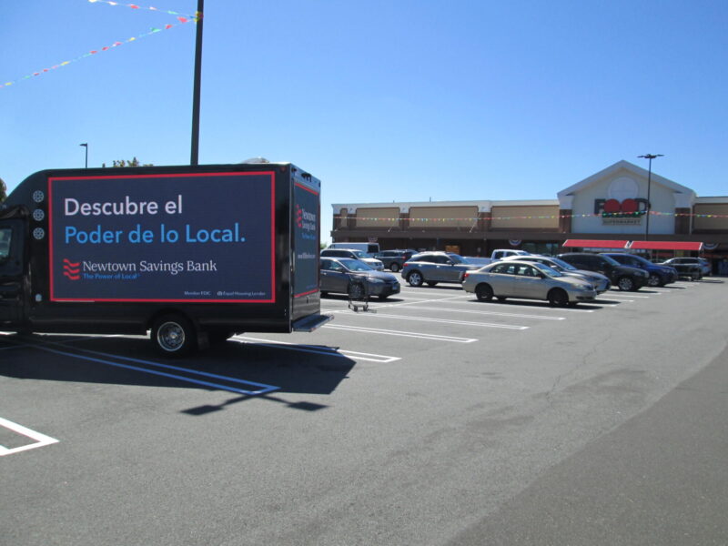 Newtown Savings Bank digital billboard truck ad in Spanish: Decubre el Poder de lo Local; Switch to the Power of Local.